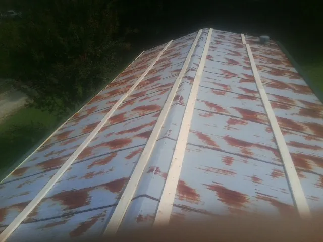 Rusted metal roof panels with new wood purlins before replacement — Storm Damage Roof Repair in Shubuta by Roofing Brothers