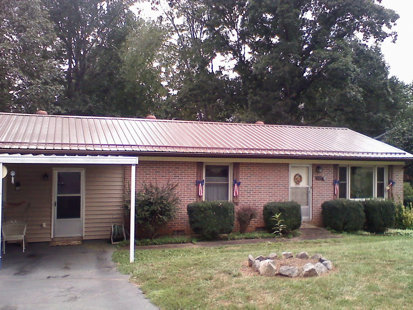 Bronze metal roof and carport on a brick ranch home — Roof Repair work by our crew in Shubuta